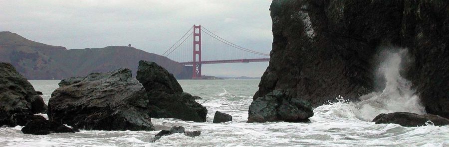 Golden Gate Bridge with rocks and waves - detail